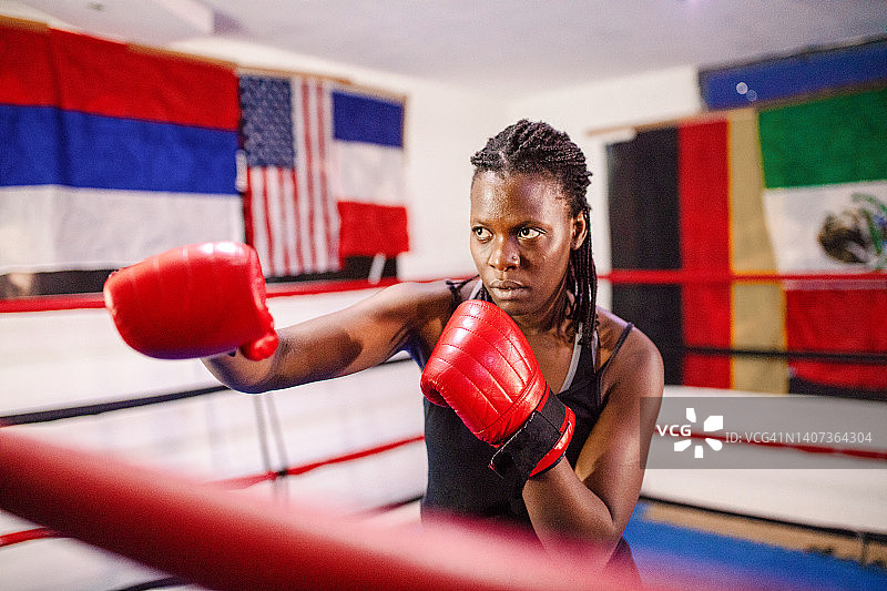 戴红色拳击手套的女拳击手在拳击台上图片素材