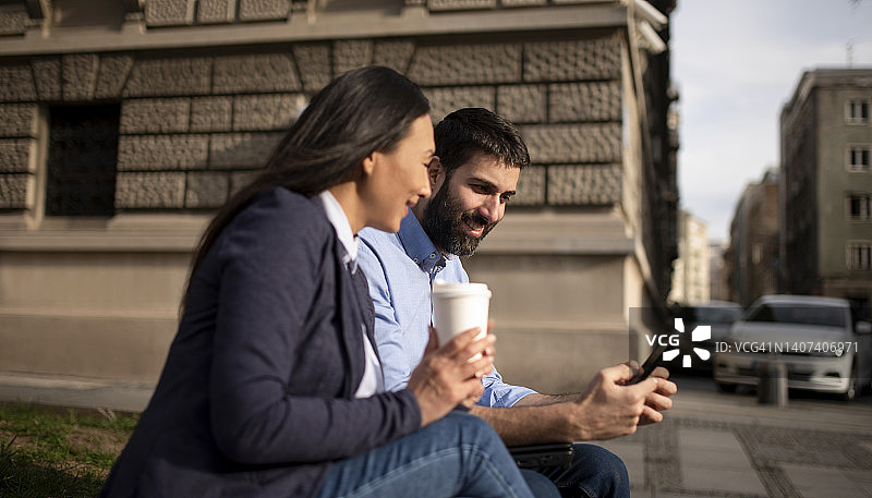 户外使用智能手机的多民族商务人士图片素材