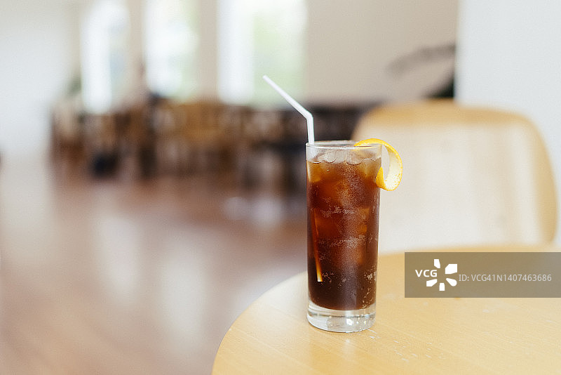 木桌上的冰美式咖啡与美丽花卉装饰（选择性聚焦）图片素材