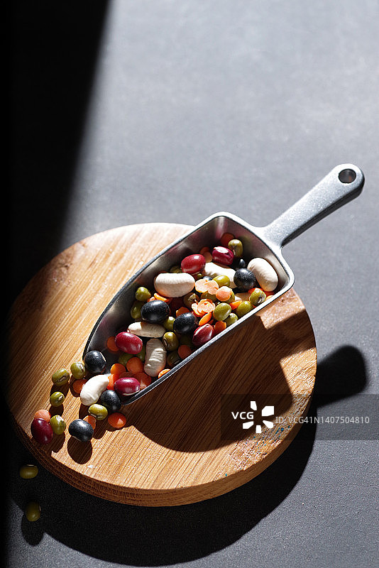 金属勺中的彩色混合豆图片素材