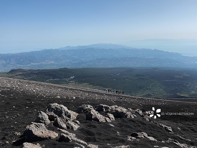 在埃特纳火山徒步旅行，欣赏海景的一群人 | 意大利西西里图片素材