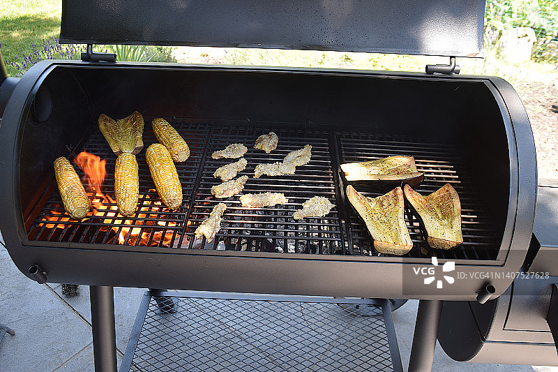 烧烤架上的甜玉米、茄子和面包虾特写图片素材
