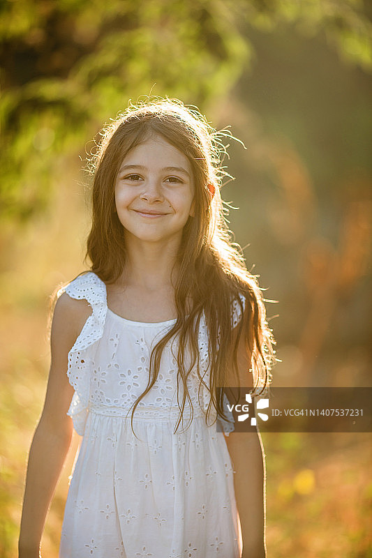 夕阳下，背光拍摄的可爱小女孩图片素材