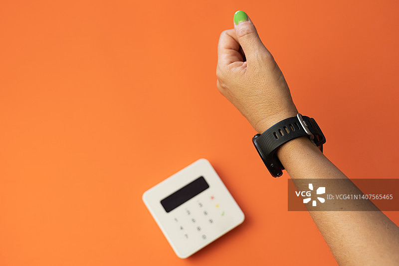 女人用智能手表在刷卡机上非接触式支付的特写图片素材