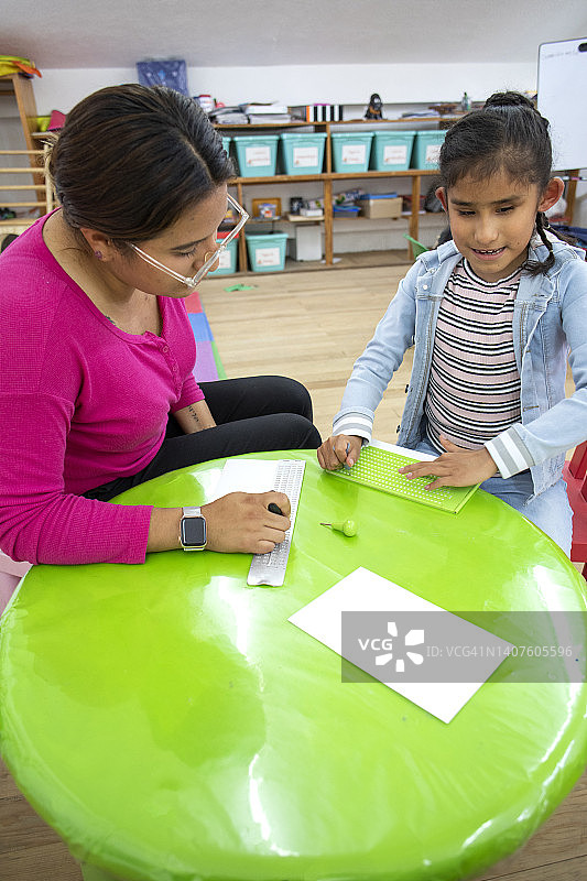 老师教盲人女孩写盲文图片素材