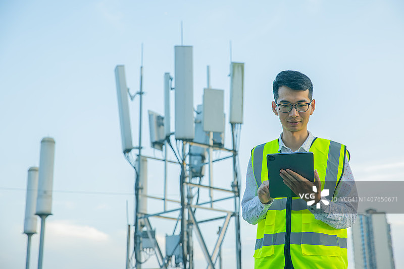 工程师使用数字平板电脑测试通信塔图片素材