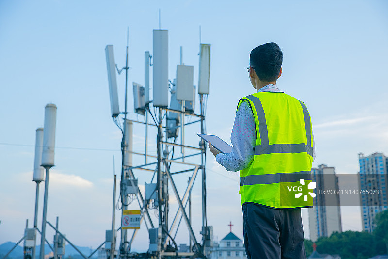 工程师使用数字平板电脑测试通信塔图片素材