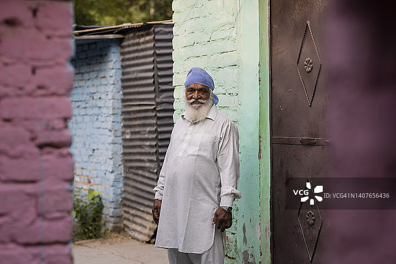 站在贫民窟地区的年长的男人图片素材