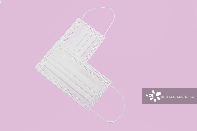 粉色背景上心形的两只白色医用口罩图片素材