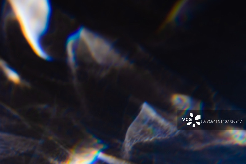 黑色背景上的彩色彩虹漏光纹理图片素材