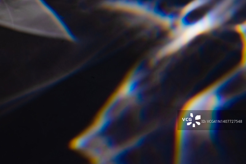 黑色背景上的彩色彩虹漏光纹理图片素材