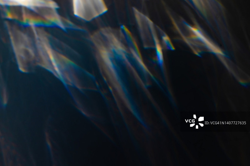 黑色背景上的彩色彩虹漏光纹理图片素材