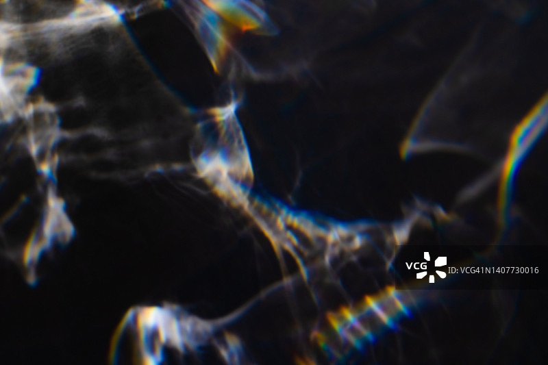 黑色背景上的彩色彩虹漏光纹理图片素材