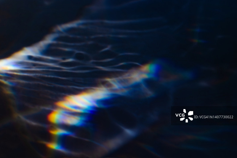 黑色背景上的彩色彩虹漏光纹理图片素材