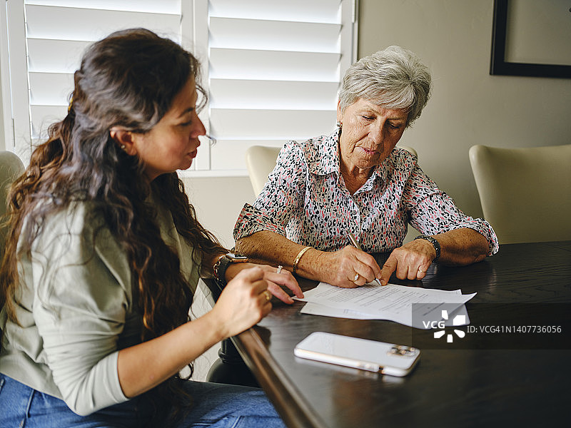 女人帮助老年人处理文件图片素材