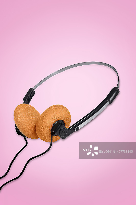 粉红色背景上的橙色耳垫耳机图片素材