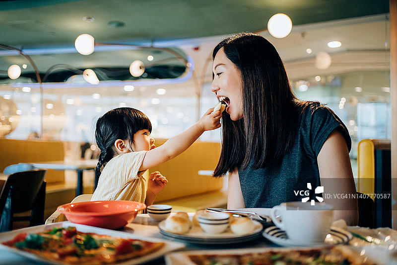 年轻亚洲妈妈和女儿餐厅午餐图片素材