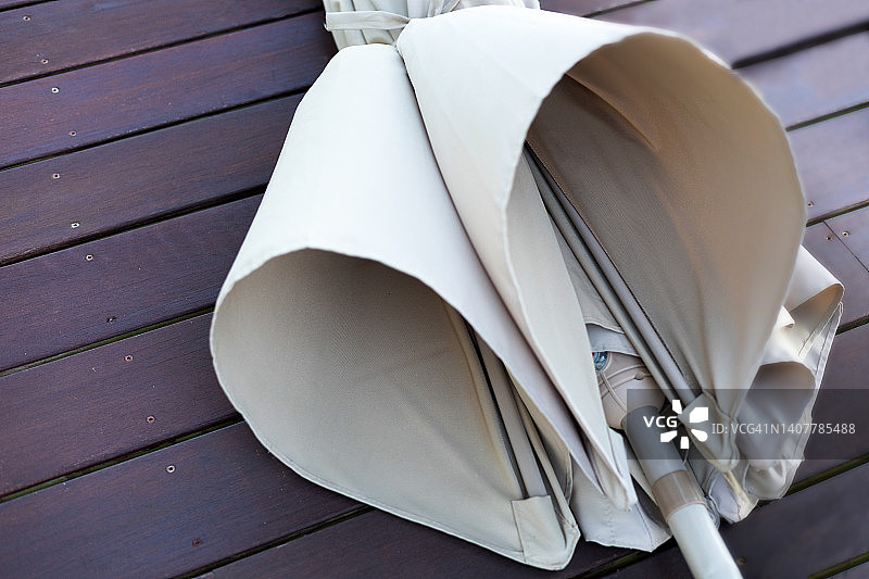 海边小屋甲板上被海风吹倒的露台伞图片素材