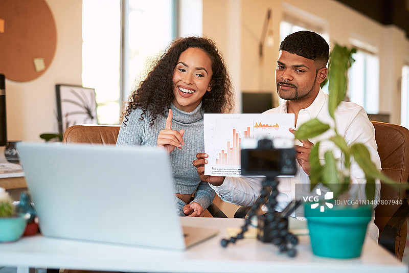 两位商人在办公室远程会议，分析图表信息，记录战略讨论图片素材