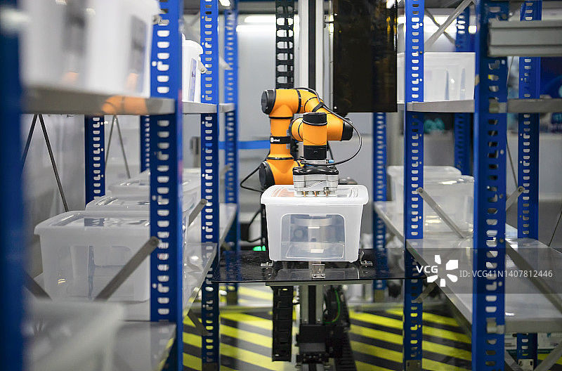 搬运机器人准备在仓库中用真空夹具将塑料制品提升到带有自动选择程序的货架上图片素材