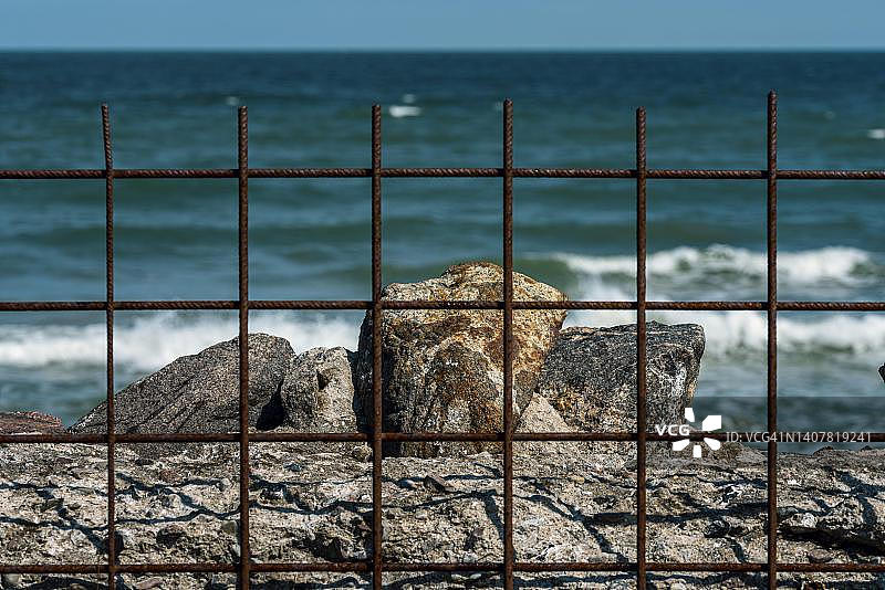 德国吕根岛普罗拉海滩上带生锈围栏的旧防火墙图片素材