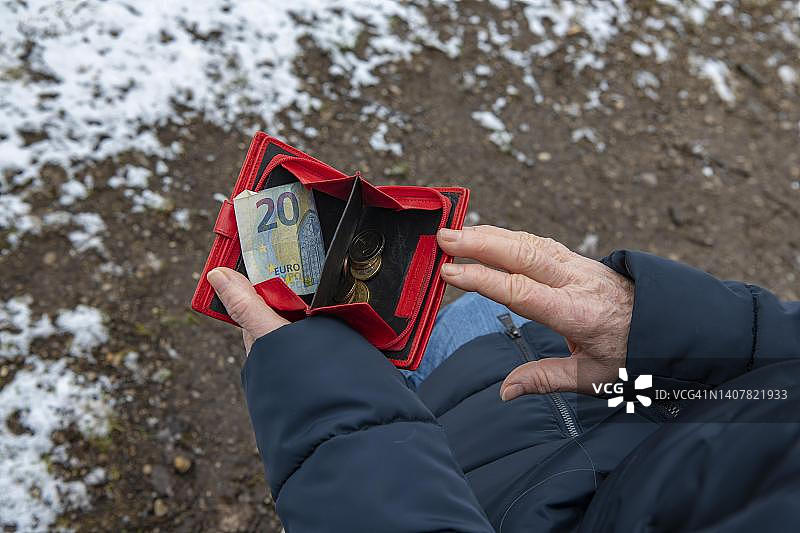 符号照片：贫困，少量金钱，消费，德国巴伐利亚州奥托布伦恩的女人在看她的钱包图片素材