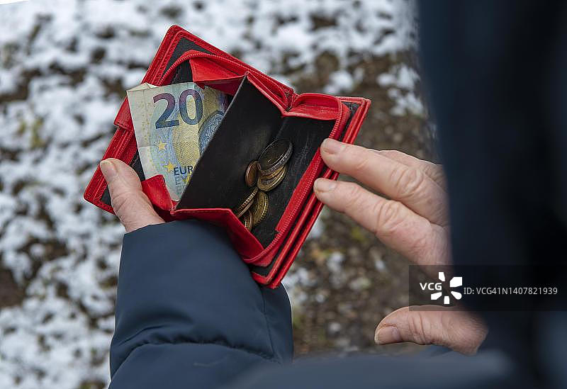 符号照片：贫困，少量金钱，消费，德国巴伐利亚州奥托布伦恩的女人在看她的钱包图片素材