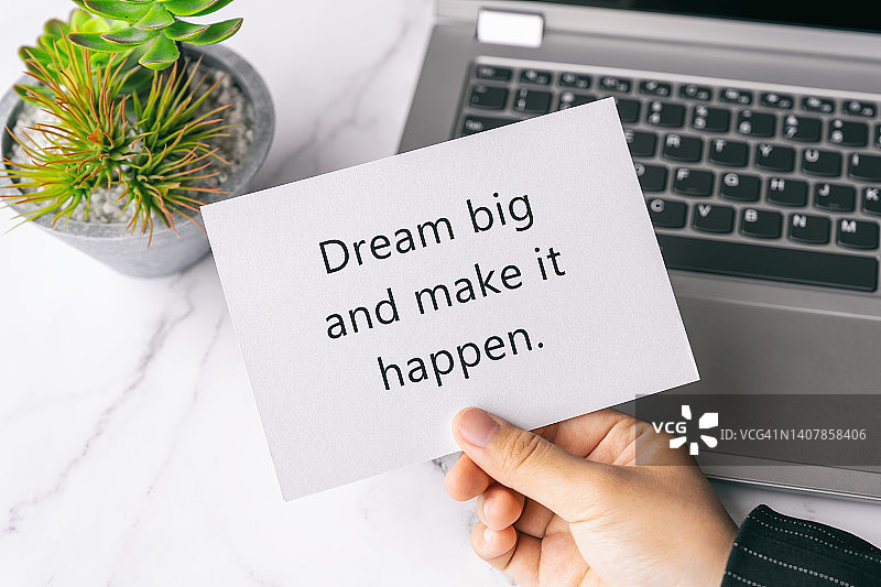 手持一张写有励志名言的纸图片素材