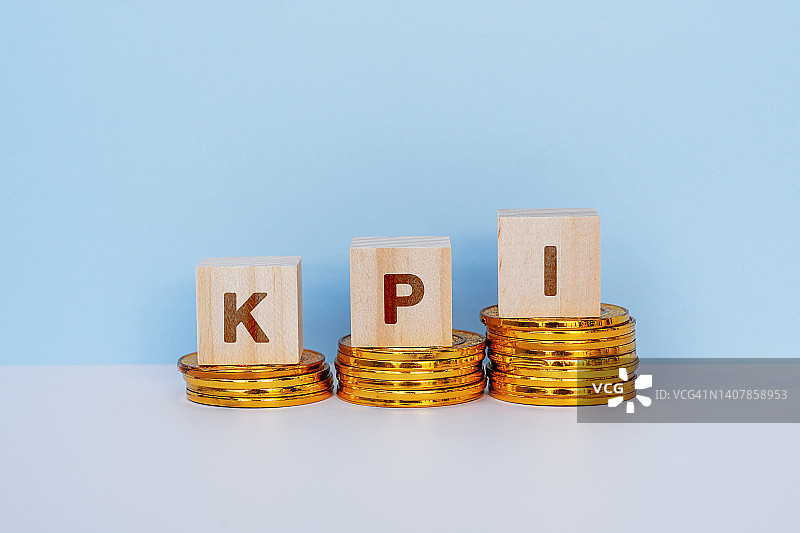 KPI-关键绩效指标，木块位于金币堆顶部图片素材