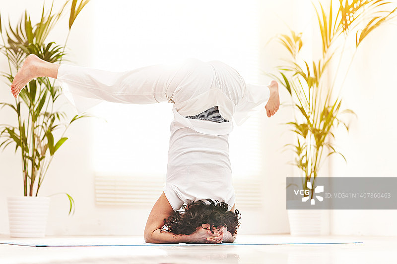 在家练瑜伽的女子做宽腿倒立式图片素材