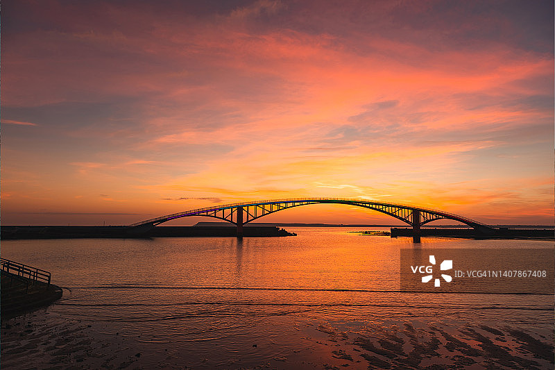 绚丽的色彩倒映在中国台湾澎湖观音桥的日落云彩图片素材