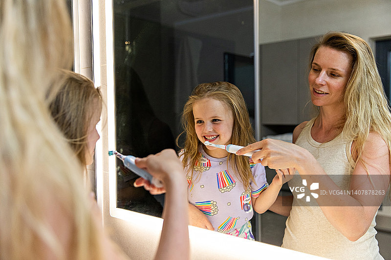 口腔卫生：母亲为女儿刷牙图片素材
