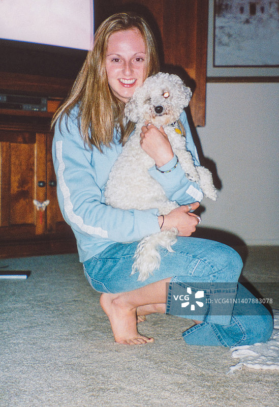 女人拥抱小狗，比熊犬，Y2k 2000年代家庭照片图片素材