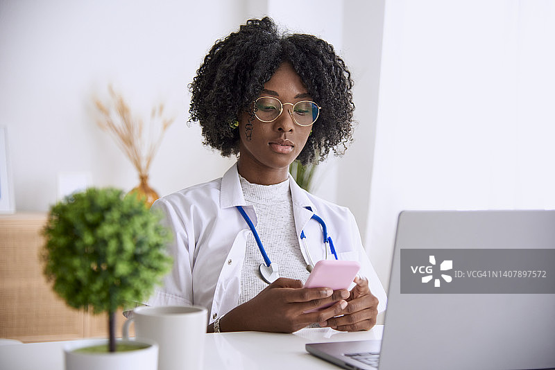 女医生使用手机和笔记本电脑工作图片素材