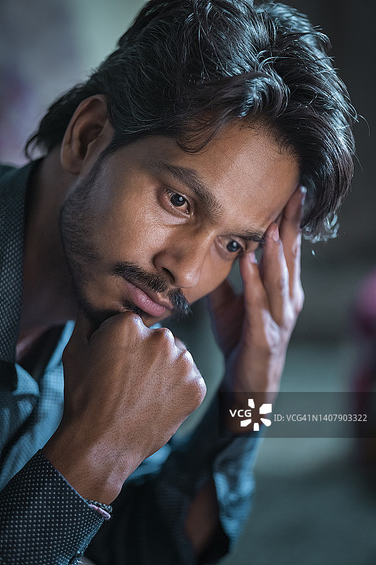 悲伤忧虑的居家抱头青年图片素材