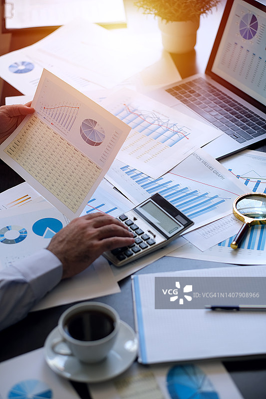用计算器计算图表数值的商人图片素材