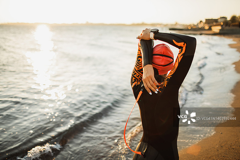 铁人三项运动员在公开水域训练前热身和伸展图片素材