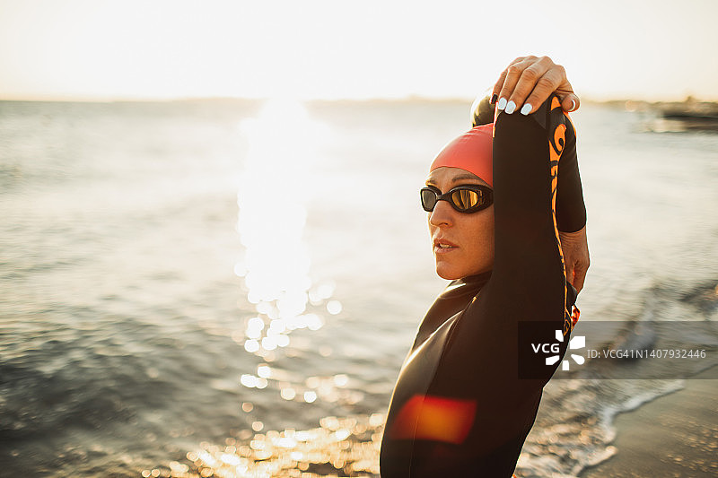 铁人三项运动员在公开水域训练前热身和伸展图片素材