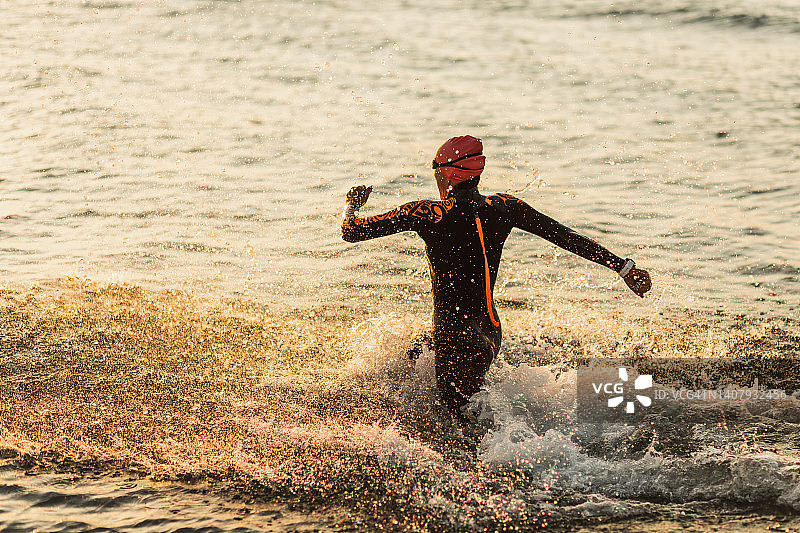 运动员在海边跑步，进行铁人三项训练图片素材