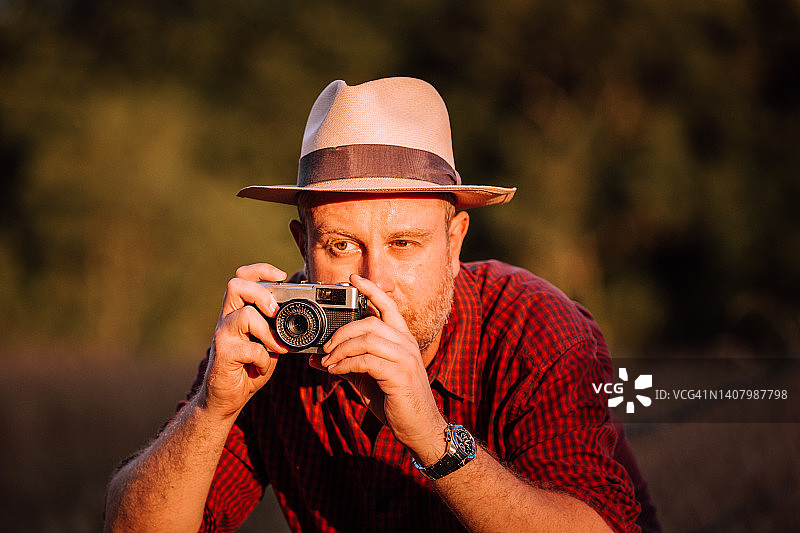 摄影师在日落时分使用老式胶片相机图片素材