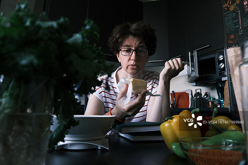 女人查看厨房里变质的奶酪图片素材