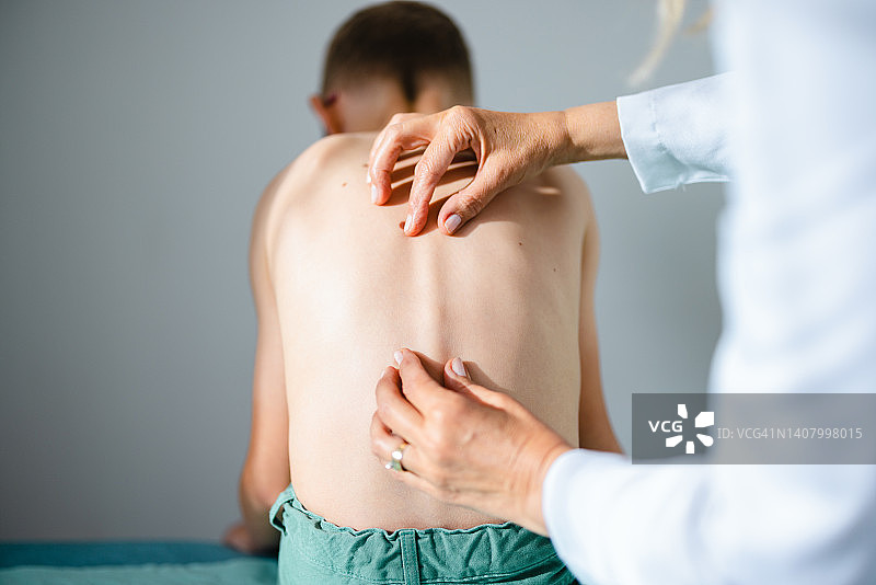 在医生办公室检查小男孩背部的特写图片素材