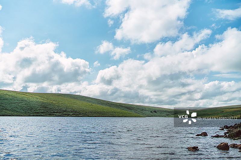 夏季阳光明媚的绿色山坡和沼泽景观图片素材