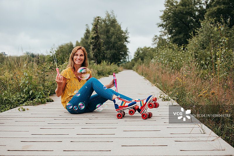 老年妇女户外玩复古溜冰鞋和泡泡图片素材