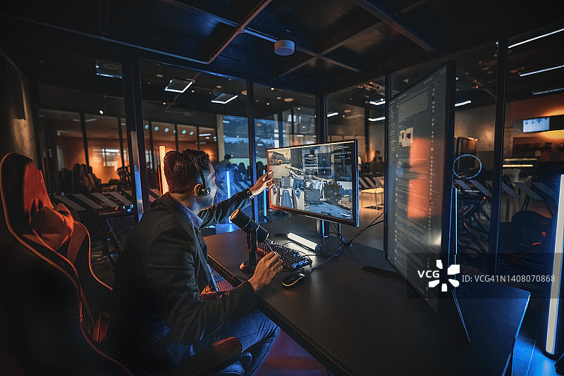 激动的亚洲游戏主播在游戏室进行直播，使用语音和即时通讯社交平台图片素材