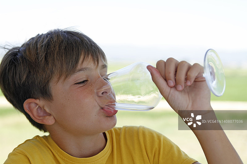 男孩在喝一杯水图片素材