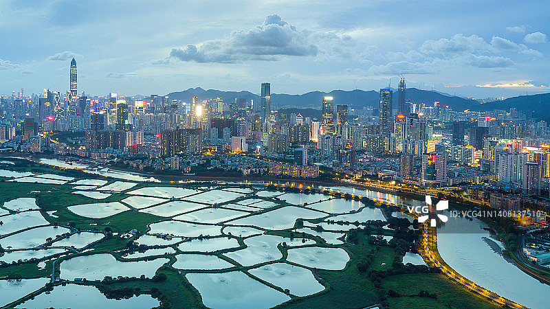 大都市旁鱼塘的黄昏航拍图片素材