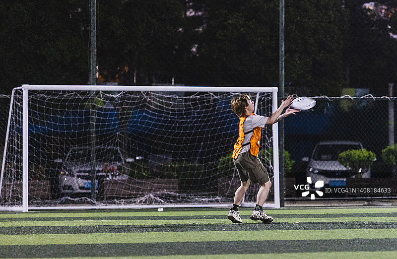 朋友们在足球场玩飞盘图片素材