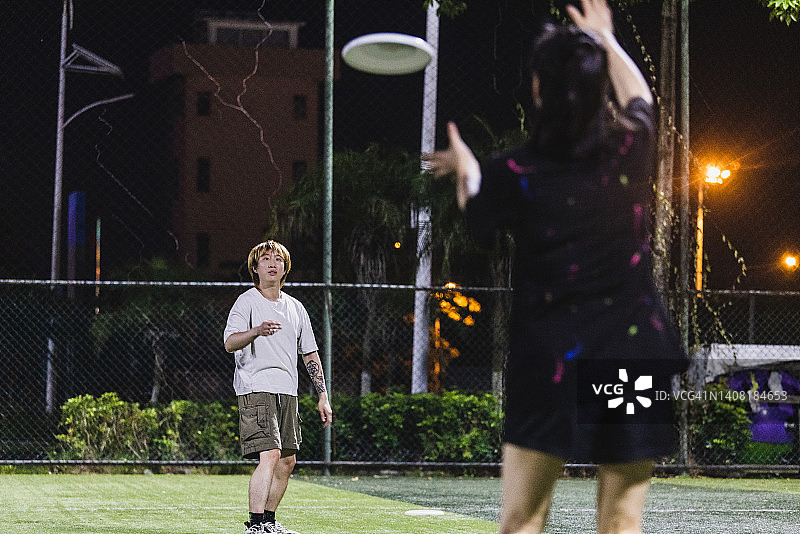 朋友们在足球场玩飞盘图片素材