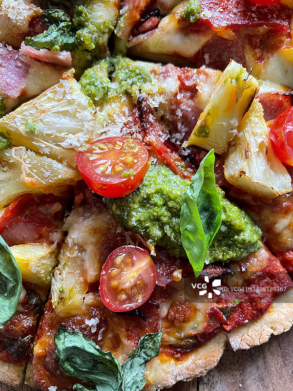 夏威夷风味自制披萨，火腿菠萝配料，番茄酱和罗勒叶点缀图片素材